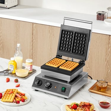 Professional double Belgian waffle maker machine on a kitchen counter with fresh waffles and fruit toppings.