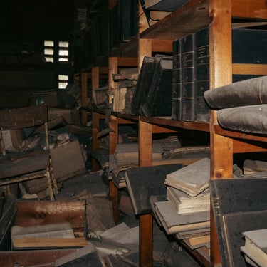 Cartons, livres, documents, papiers en désordre sur des étagères bancales