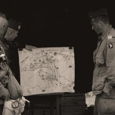 Trois soldats devant une carte du débarquement de 1944