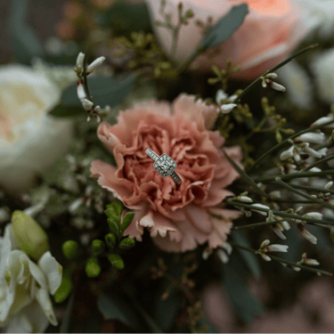 une fleur rose pêche avec une bague argent au centre