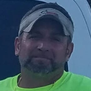 a man in a green shirt and a white hat