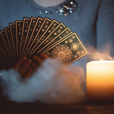 a woman holding a card game of cards and a candle