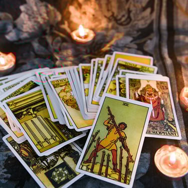a bunch of tarot cards with candles and candles