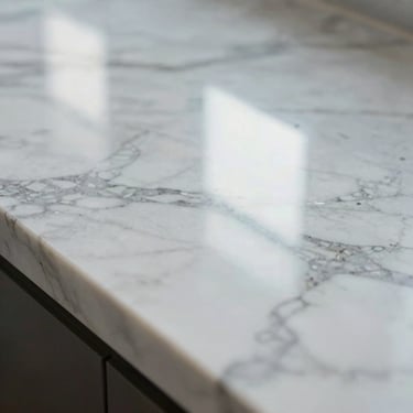 Macro shot of polished white Carrara marble showing perfect geometric reflection lines under bright natural light.
