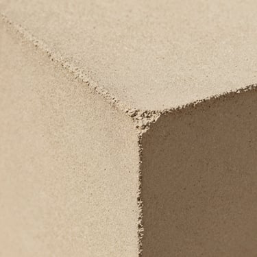 Macro close-up of warm bone concrete, fine sand aggregate, matte tactile texture, soft diffused lighting.