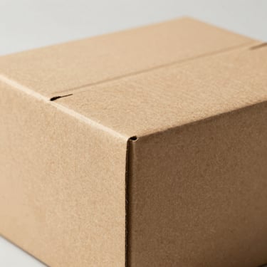 Close-up of a custom corrugated mailer box showing clean fluting and crisp soy-based ink printing, neutral minimalist backdrop, 85mm