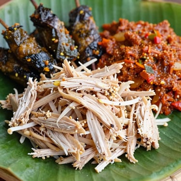 Macro shot of authentic Balinese Nasi Campur with shredded chicken, sate lilit, and fresh sambal matah on a banana leaf