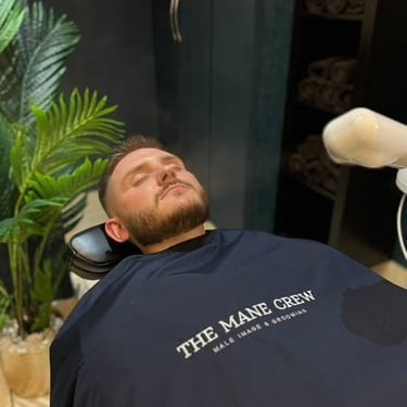 Man lying on a barber shair at the mane crew barbers