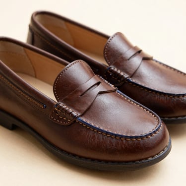 Elegant brown leather loafers for children, showcasing meticulous stitching details, shallow depth of field