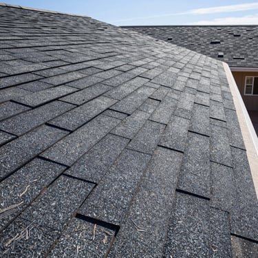 Close-up architectural shot of flawless shingle alignments on a residential roof, bright New Mexico desert sunlight casting sharp geometric shadows.