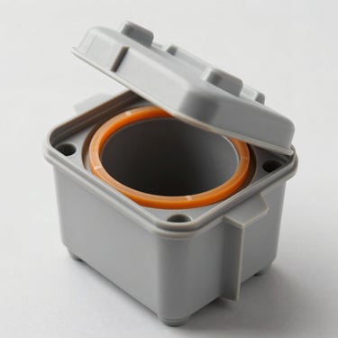 Macro high-resolution technical photograph of a gray industrial thermoplastic junction box, showing the detailed orange polyurethane foam gasket seal on the inside of the lid, clean studio lighting, neutral background, isometric 45-degree angle.