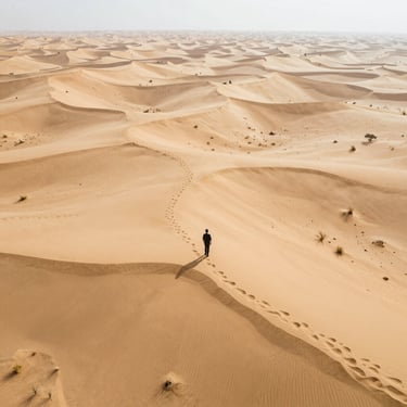 Aerial view of a remote desert area with faint outlines of hidden structures beneath the sand.
