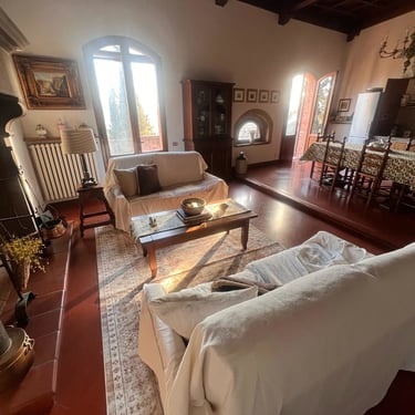 Spacious rustic living room with coffered wood ceiling and terracotta floors in a historic Certaldo Alto home