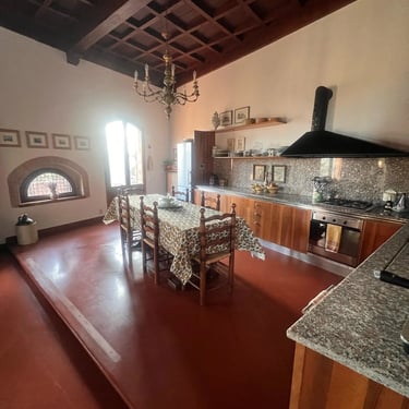 Spacious dining room and kitchen with traditional coffered wood ceiling in a historic home in Certaldo Alto