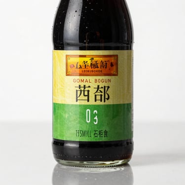 Macro shot of authentic Lee Kum Kee soy sauce bottle label, bright commercial studio lighting, clean reflection.