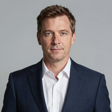 A friendly middle-aged man with glasses and a casual shirt, smiling.