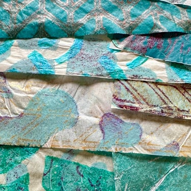 Stack of teal collage papers with layered patterns