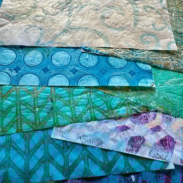 Teal collage papers stacked with layered stencil patterns