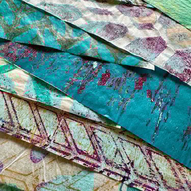 Stack of teal and neutral collage papers with layered paint textures