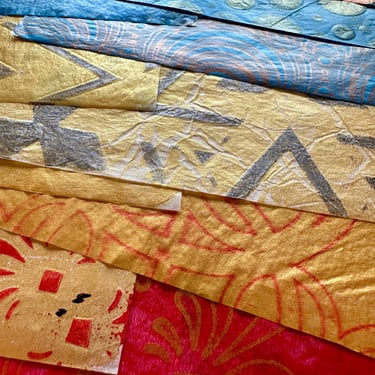 Stack of colorful hand-painted collage papers with layered designs