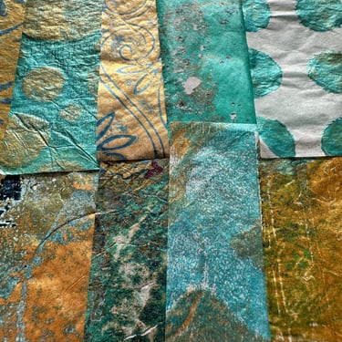 Stack of teal and gold iridescent collage papers with layered stencil textures