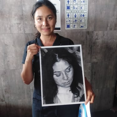Mujer sosteniendo retrato realista a grafito y carboncillo de mujer con ojos cerrados, obra de arte