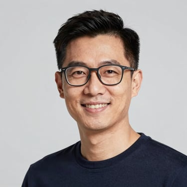 Professional headshot of a friendly male numerologist, modern glasses, neutral grey background, sharp focus