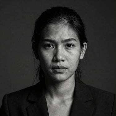 Black and white portrait of a female Thai journalist, low-key dramatic lighting, intense gaze, desaturated tones, 1:1 aspect