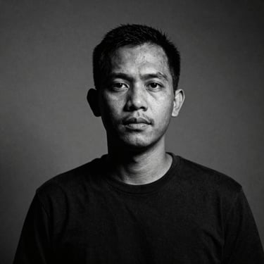 Black and white portrait of a male Indonesian journalist, gritty photojournalism style, deep shadows, 35mm film grain, 1:1 aspect