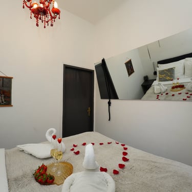 A mirror across the bed and its reflection in it.