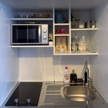 Fully-equipped-kitchenette-with-stovetop-fridge-freezer-microwave-utensils-dishes-cofee-tea-spices-wine-and-champagne-glasses