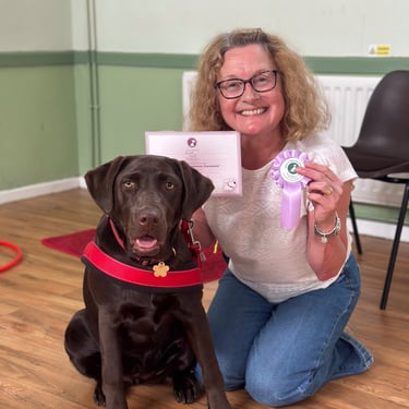 Chocolate Labrador & handler smiling after passing their KC puppy foundation dog training class