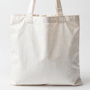 Bright high-key product photo of a white cotton tote bag standing upright, soft natural daylight, 50mm