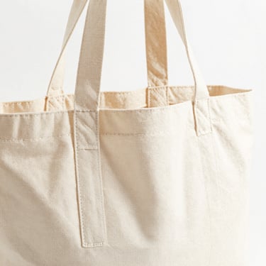 Bright high-key product photo of a heavy canvas bag with thick handles, soft natural daylight, 50mm
