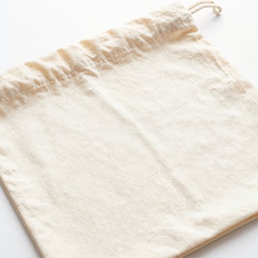 Bright high-key product photo of a flat promotional cotton bag, soft natural daylight, 50mm