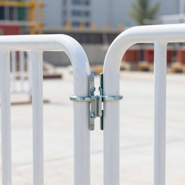 Bright commercial product shot of a heavy-duty steel site barrier, outdoor construction site setting, natural daylight, robust welded joints clearly visible, 35mm lens