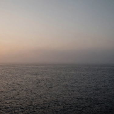 Desolate misty northern coastline with twilight fog, wide environmental landscape evoking solitude, moody film photography