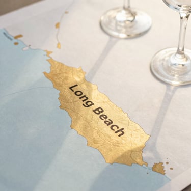 A stylized, elegant map graphic of Long Beach and surrounding coastal Southern California, with warm gold accents highlighting the service area, clean minimalist design, high contrast