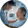 A nurse using a stethoscope to examine an elderly female patient in a clinical setting.