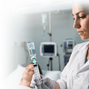A doctor in a clinic prepares a medical syringe for a patient's stem cell treatment.