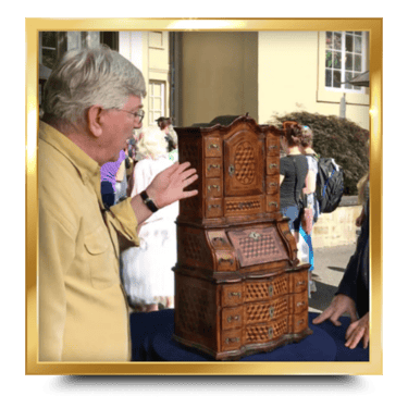 Dr. Glenn P. Wood standing next to a tall antique wooden cabinet