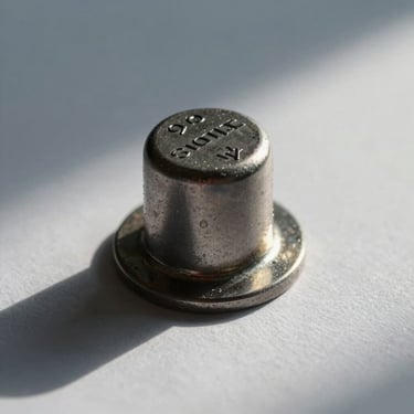 Macro close-up of a heavy security seal on high-grade paper, sharp geometric angles, cold north-facing daylight.