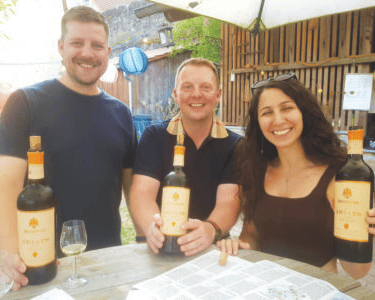 Three people display Armenian wines. (Photo courtesy of E. Drayss)