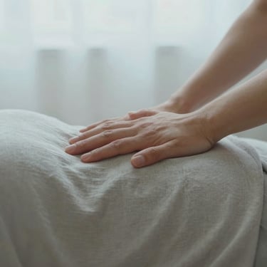 Close-up of a doula's hand gently resting on a laboring mother's shoulder, soft overcast light, warm neutral textiles