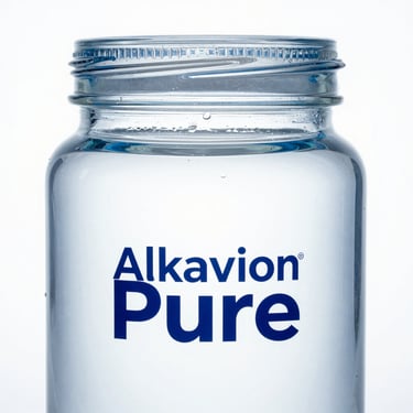 Macro product shot of a minimalist glass 20-litre Alkavion Pure jar, clinical white background, sharp blue refraction highlights
