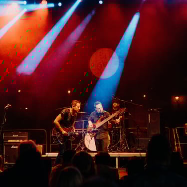 A lively band performing on stage with vibrant lighting in a night setting.
