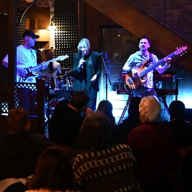 Jozef Bobula on bass with a female singer and a guitar player during a live concert