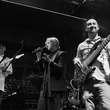 Jozef Bobula on bass with a female singer and a guitar player during a live concert