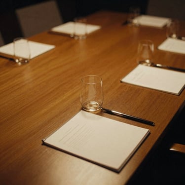 Close-up of a perfectly aligned corporate conference table with bespoke stationery, soft golden lighting, warm ambient glow, shallow depth of field, 35mm film