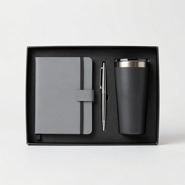 Premium corporate gift set including a custom notebook, metal pen, and tumbler, neatly arranged in a matte black box